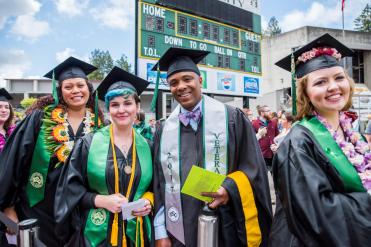 Four students wearing graduation regalia