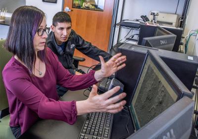 Two people looking at maps on a computer